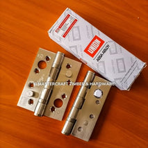 Silver door hinges with a white box labeled 'Assa Abloy' on a wooden surface