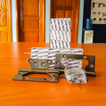 Metal hinges with packaging on a wooden surface