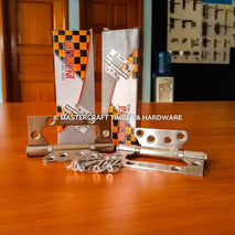 Metal hinges with packaging on a wooden surface, featuring 'Mastercraft Timber & Hardware' branding.